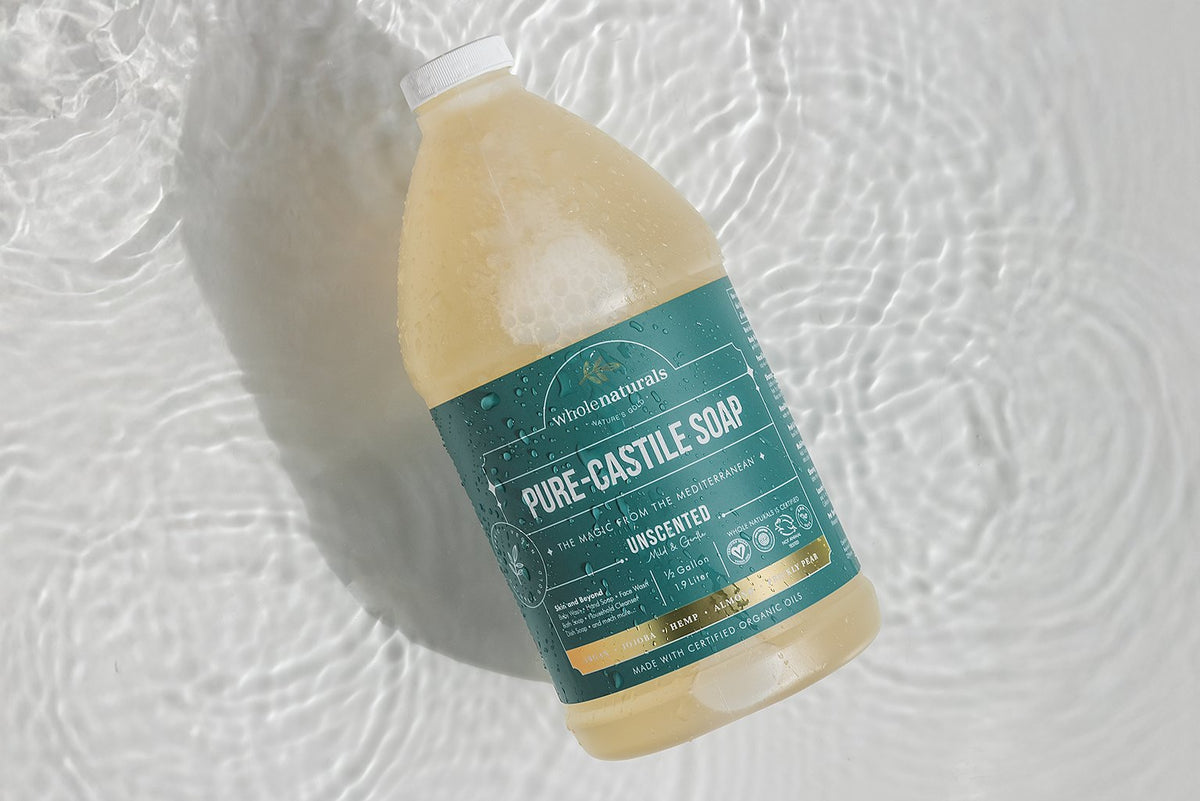 Half gallon bottle of unscented Pure-Castile Soap lying in shallow rippling water