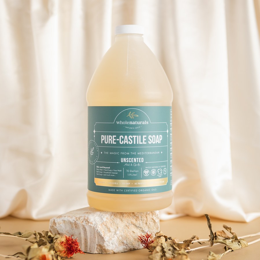 64 oz bottle of unscented Pure-Castile Soap on a stone block against cream drapery with dried flowers
