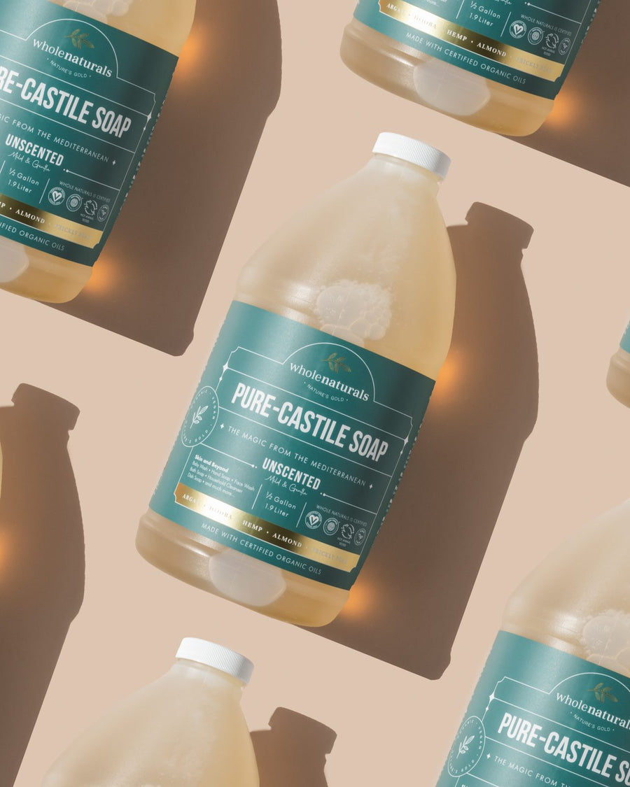 Several 64 oz bottles of Whole Naturals Pure-Castile Soap arranged together